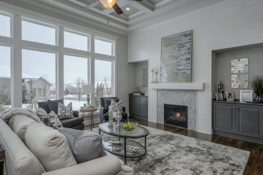 Varese Great Room With Fireplace, Large Windows And Built-in Cabinetry By Comerio Homes
