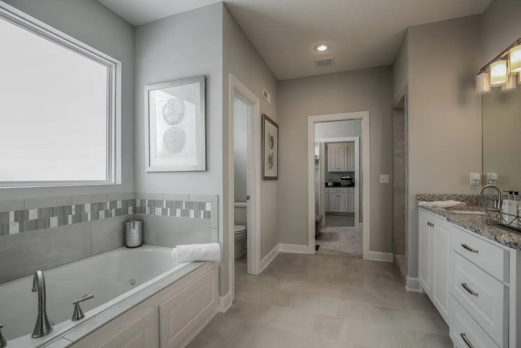 Varese Floor Plan Primary Bathroom With Soaking Tub, Tiled Shower, And Double Vanity By Comerio Homes