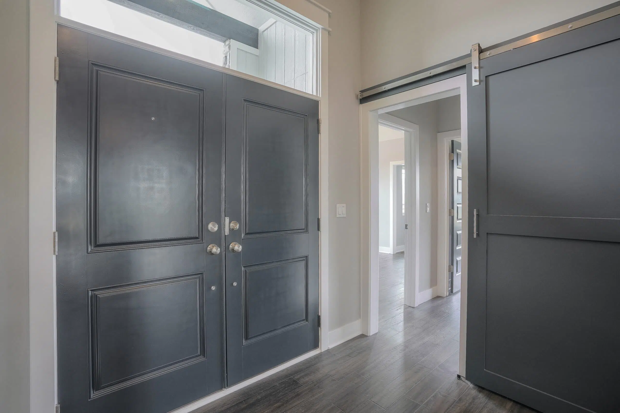 Verona III Entry By Comerio Homes Featuring Double Front Doors, A Transom Window And Sliding Barn Door.