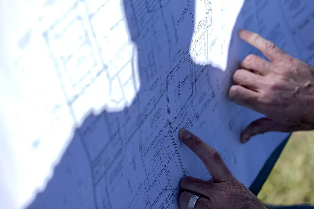 Reviewing Details On A Comerio Homes Residential Floor Plan Blueprint