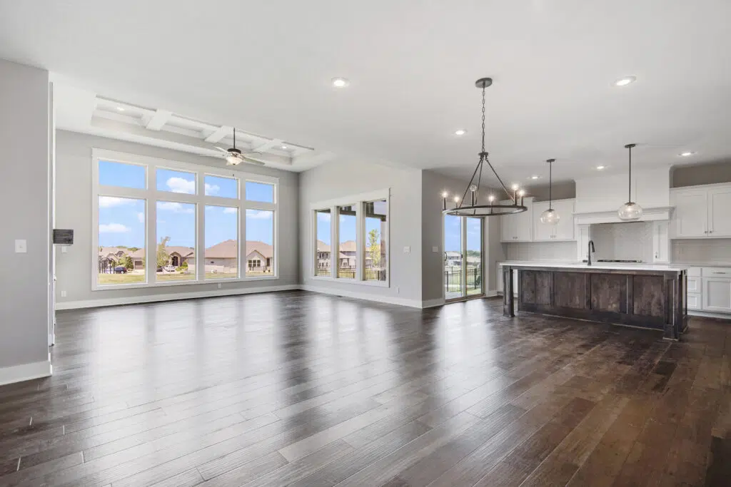 Lago Open-concept Great Room And Kitchen With Large Windows, Wood Flooring, And Center Island