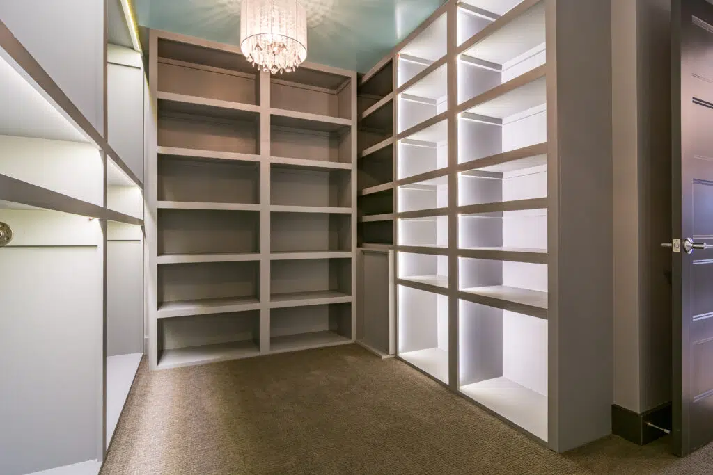 Justina Custom Walk-in Closet With Built-in Shelving, Integrated Lighting, And Chandelier.