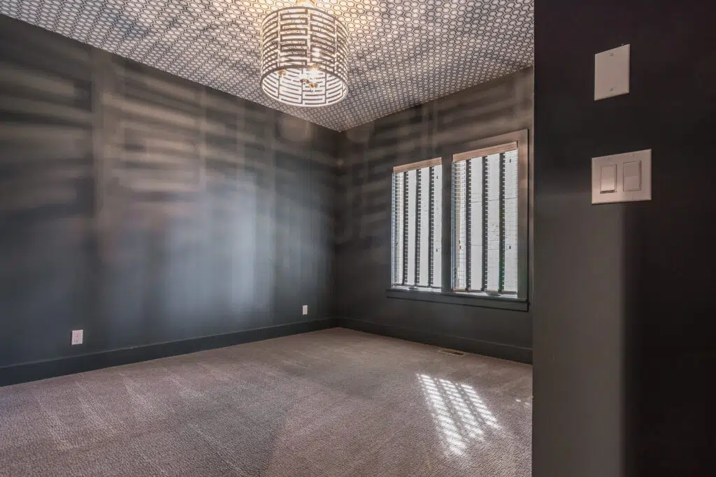 Justina Floor Plan Bedroom By Comerio Homes Featuring Dark Walls, Patterned Ceiling, Statement Light Fixture And Large Windows.