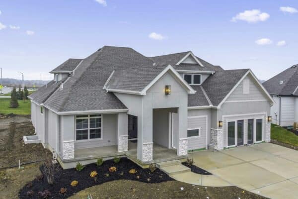 The exterior of the Varese Expanded home plan, complete with landscaping and freshly-poured sidewalk and driveway elements. Located in Coventry Valley, Overland Park.