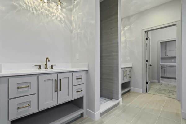 The Varese Expanded home design's master suite bathroom, featuring dual sinks separated by access to a private shower/sauna room.