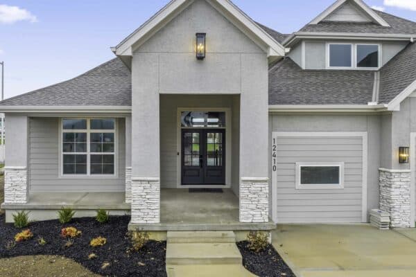 The exterior of the Varese floor plan, featuring covered porch with modern stone accents.