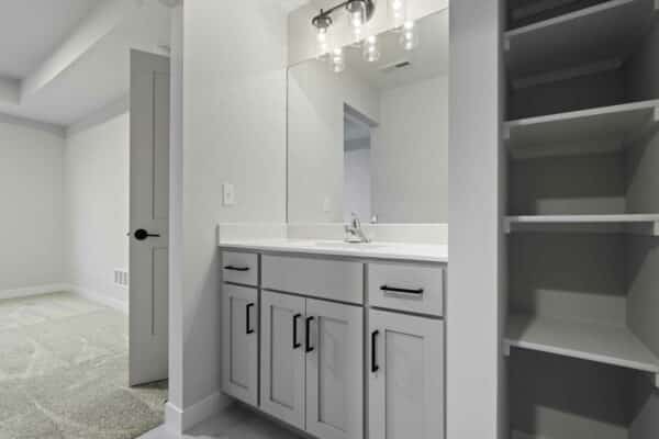 The interior of the Milano floor plan by Comerio homes, showcasing a bathroom suite and integrated storage options.
