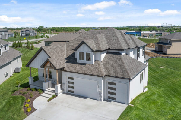 The Siena Story-and-a-half home plan design, located in Coventry Valley, featuring wood and stone facade accents.