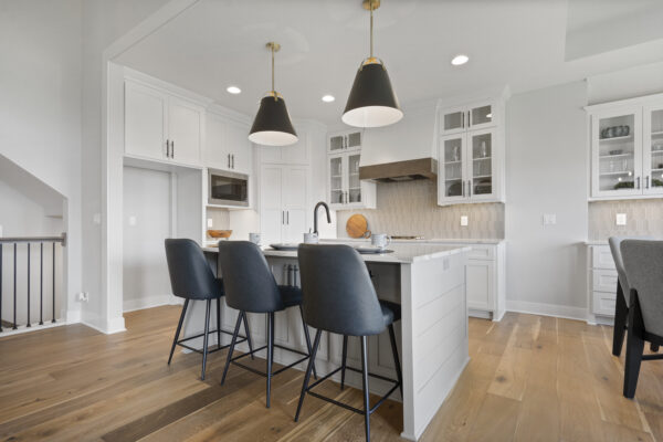 The kitchen island and breakfast bar seating with modern range hood and lightning fixtures.