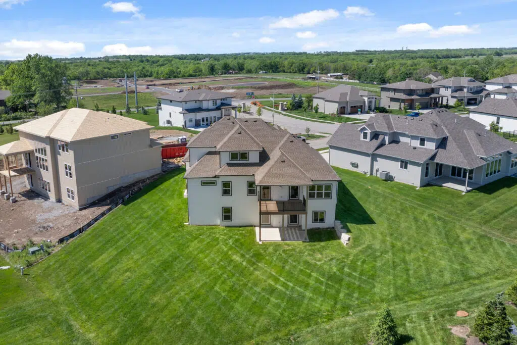 Aerial Rear View Of The Comerio Homes Siena 1.5 Showing The Spacious Backyard, Elevated Deck, And Walkout Lower Level.