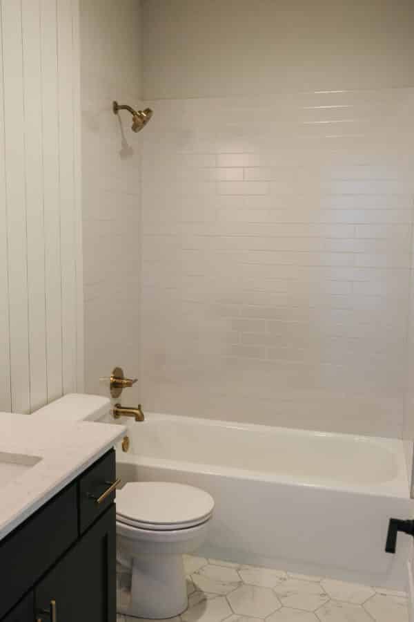 One of the bathrooms within the Siena floor plan, showcasing modern, geometric flooring and gold finish fixtures.