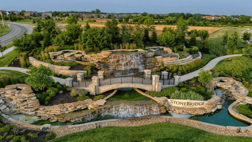 Aerial View Of Stonebridge Community Entrance With Landscaped Waterfalls And Stone Bridge