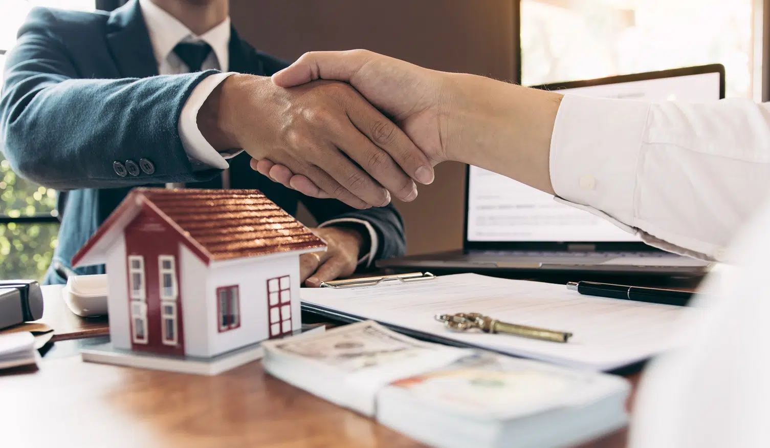 Handshake Over Home Purchase Agreement With House Model And Keys