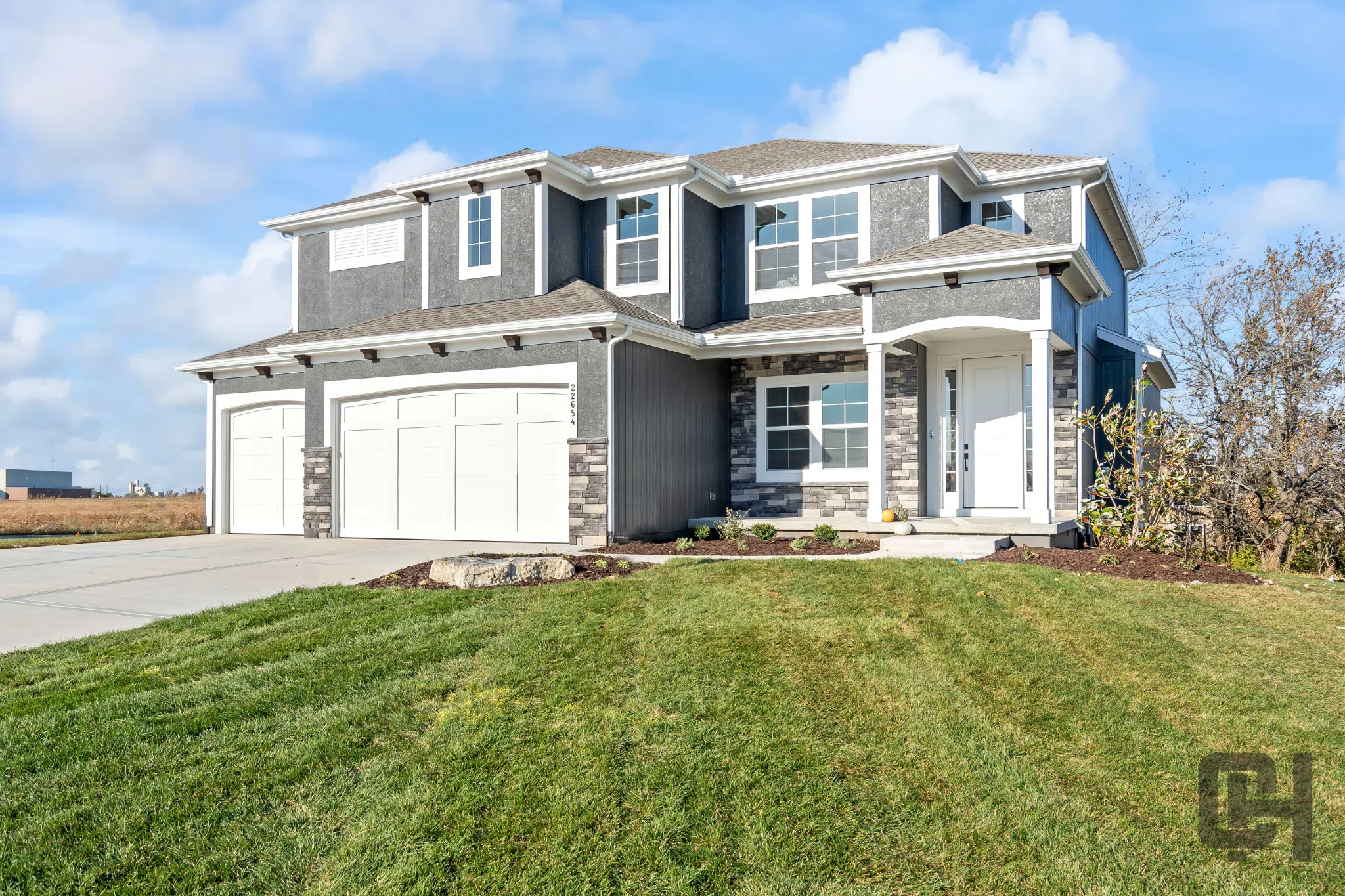 Comerio Homes Justina Elevation B With Three-car Garage And Stone Accents.