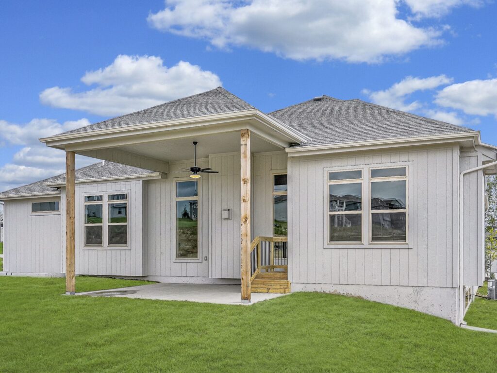 Rear Exterior Of The Verona III By Comerio Homes Featuring A Covered Patio And Spacious Backyard.