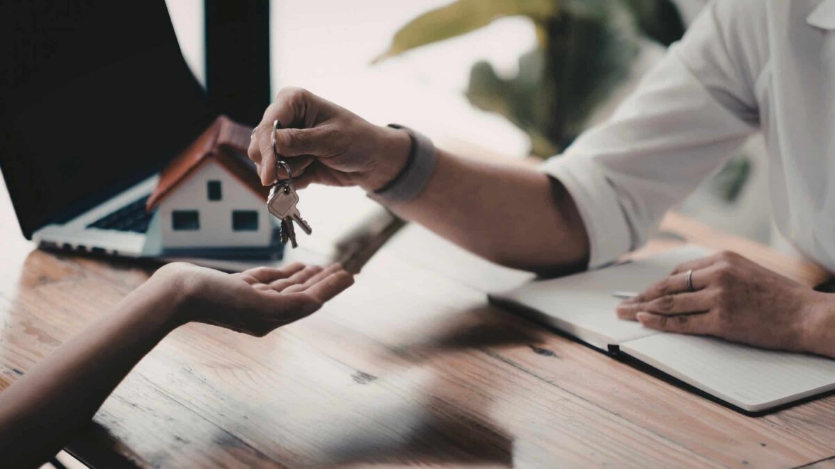 Home Key Handoff During Meeting Representing Final Step In Home Building Process By Comerio Homes