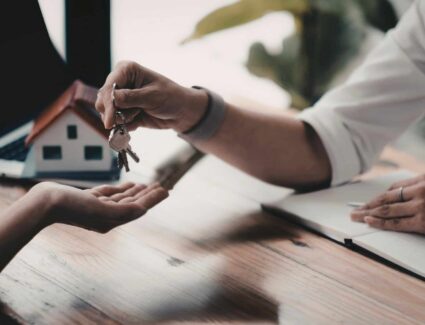 Home Key Handoff During Meeting Representing Final Step In Home Building Process By Comerio Homes