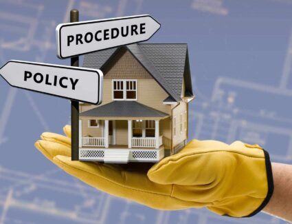 House Model Held In Hand With Policy And Procedure Signs Representing Home Building Process And Guidelines By Comerio Homes