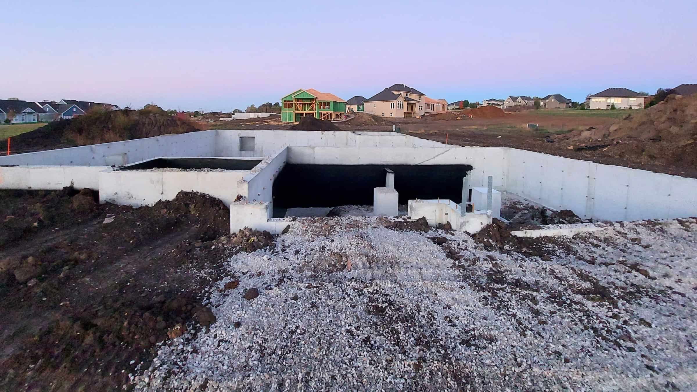 New home foundation stage with poured concrete and site preparation by Comerio Homes