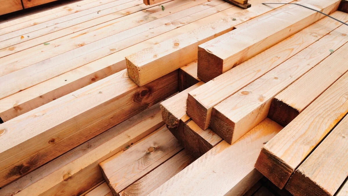 Stacked lumber materials used for framing in home construction emphasizing quality and precision by Comerio Homes