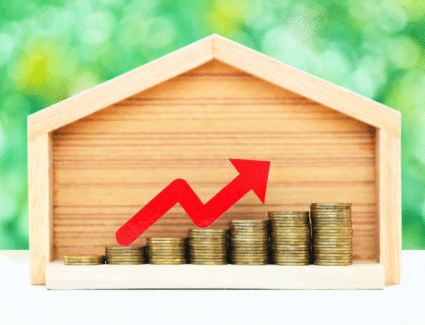 Rising Home Value Represented By House And Stacked Coins